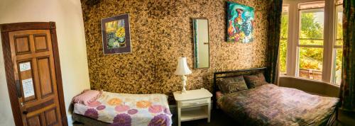 a small bedroom with two beds and a window at The Palace Backpackers in Nelson