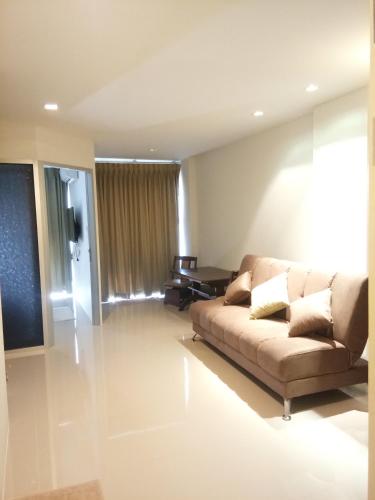 a living room with a couch and a table at Mosaic Condominium by Malai in Mae Pim