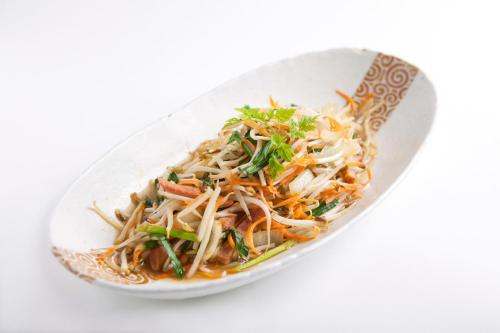 a white plate of food with noodles and vegetables at Almont Hotel Naha Kenchomae in Naha