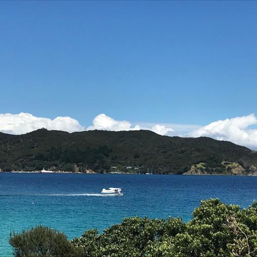 a boat in the middle of a large body of water at Tipi and Bobs Waterfront Lodge in Tryphena