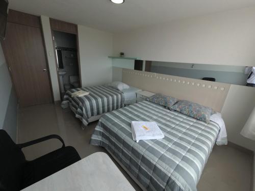 a bedroom with two beds with a book on it at Fragata Camaná in Camaná