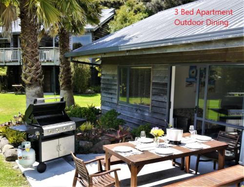 a patio with a barbecue and a table and chairs at Bay of Islands Holiday Apartments in Paihia
