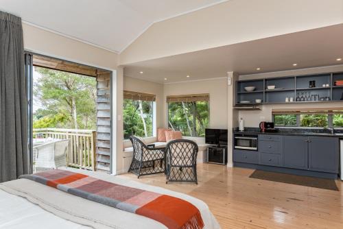 a bedroom with a bed and a kitchen with a balcony at Bay of Islands Holiday Apartments in Paihia