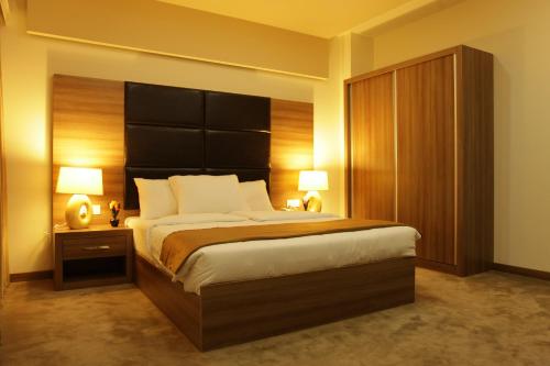 Un pat sau paturi într-o cameră la Quaint Hotel Erbil