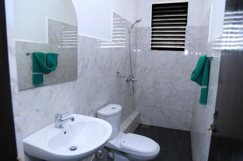 a bathroom with a sink and a toilet and a mirror at Hillstreet Villa in Dehiwala