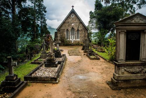 an old church with a cemetery in front of it at Royal Majesty Bungalow in Hatton
