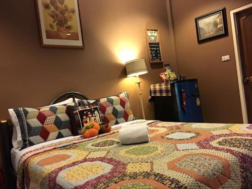 a bedroom with a bed with a quilt on it at The Green Land Farm in Si Khio