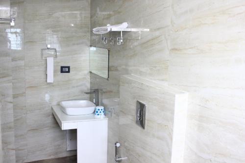 a bathroom with a toilet and a sink and a shower at Hotel Shreemoyee Inn - Kamakhya Temple in Guwahati