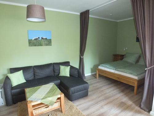 sala de estar con sofá y cama en Ferienwohnung in Osterdeichstrich, en Oesterdeichstrich