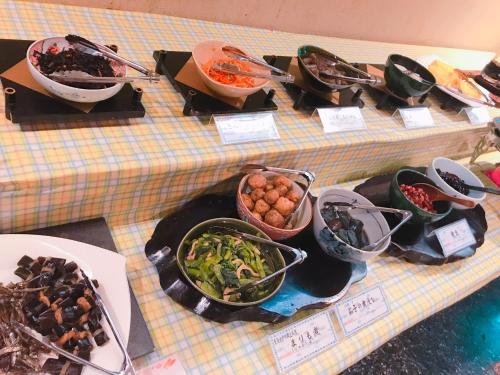 una tavola ricoperta di piatti e ciotole di cibo di Breezbay Hotel & Resort Gero a Gero