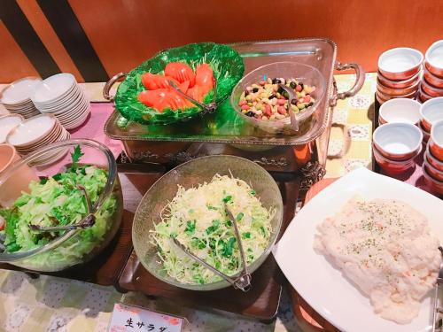 un tavolo con due vassoi di cibo sopra di Breezbay Hotel & Resort Gero a Gero