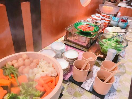 un tavolo con verdure e ciotole di cibo sopra di Breezbay Hotel & Resort Gero a Gero