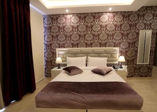 ein Schlafzimmer mit einem großen Bett mit zwei Kissen in der Unterkunft Beirut Hotel in Amman