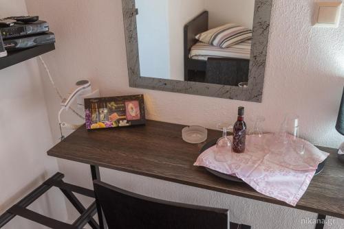 a table with a bottle of wine and a mirror at Studio Porto Marina in Sykia Chalkidikis