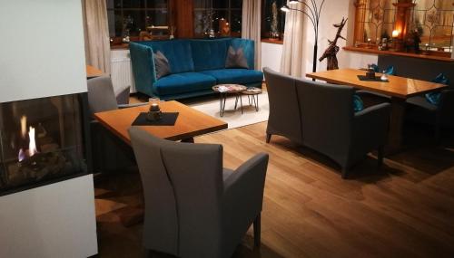 a living room with chairs and tables and a fireplace at die Aussicht in Finkenberg