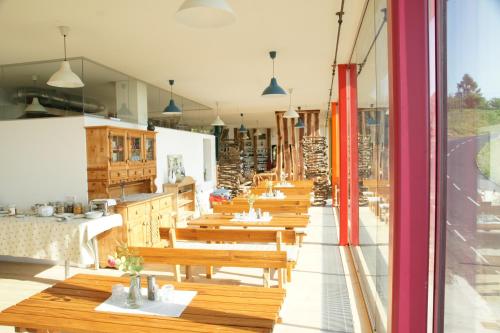 una fila de mesas y bancos de madera en un restaurante en Samenkönig Pschait Handels GmbH, en Gamlitz