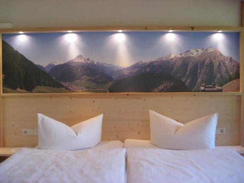 a bedroom with two beds with a large painting on the wall at Haus Brigitte in Nauders