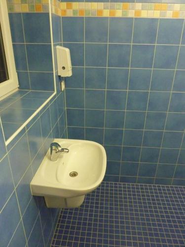 a bathroom with a sink and a blue tiled wall at Relax Centrum Gól in Loučná nad Desnou