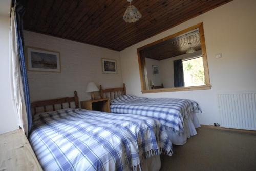 En eller flere senger på et rom på Woodcroft Cottage