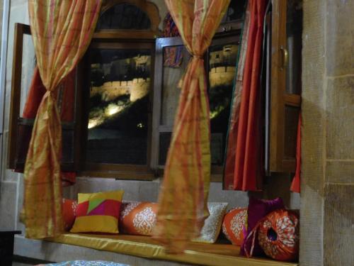a window with curtains and a couch in a room at Shahi Palace Hotel Jaisalmer in Jaisalmer