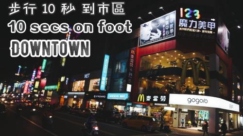 a city street at night with neon signs at Audi Garden Business Hotel in Taoyuan