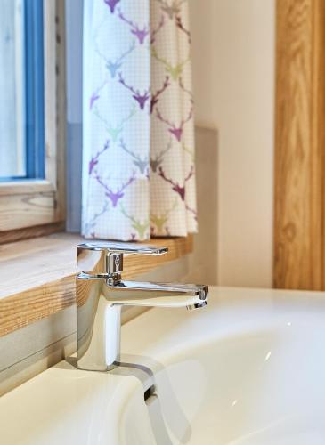 a sink with a faucet in a bathroom at Chalet Guter Hirte in Saalbach Hinterglemm
