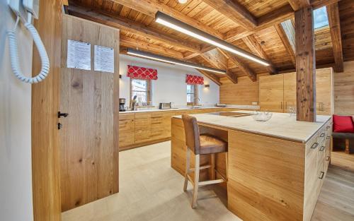 a kitchen with wooden cabinets and a wooden door at Chalet Guter Hirte in Saalbach Hinterglemm