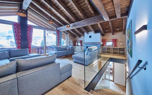 a living room with a couch and a glass table at Chalet Guter Hirte in Saalbach Hinterglemm