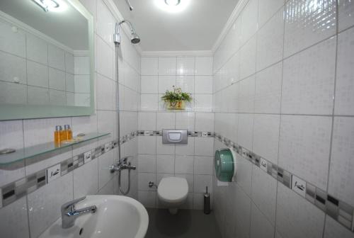 une salle de bain blanche avec toilettes et lavabo dans l'établissement Hotel Mithat, à Ankara