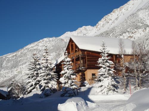 a log cabin in the snow with snow covered trees at Le Chalet d'en Hô in Névache