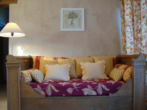 a couch with pillows on it in a room at La Guéritaulde in La Tour-dʼAigues