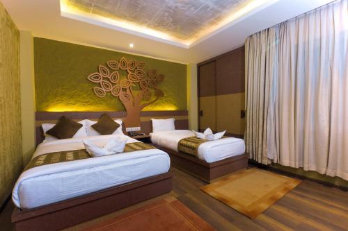 Chambre d'hôtel avec 2 Lits et une fresque murale sur les arbres dans l'établissement Bodhi Boutique Hotel, à Katmandou