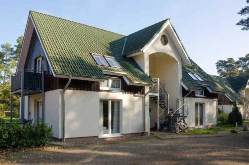 トラッセンハイデにあるFewo Toni_s Strandidyll_HERRの緑屋根の大白い家