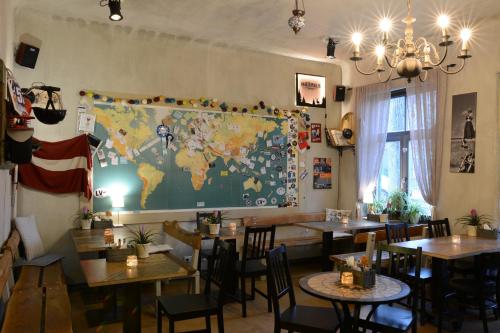 un restaurante con mesas y un mapa del mundo en la pared en Two Wheels, en Riga