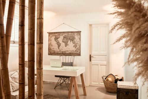 a desk with a laptop on it in a room at Mykonos No5 Luxury Suites & Villas in Ornos