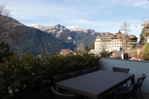 a table on a balcony with a view of mountains at Hirschen Residence 2 in Wengen
