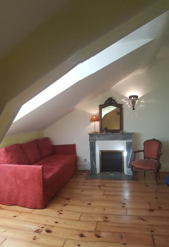 ein Wohnzimmer mit einem roten Sofa und einem Kamin in der Unterkunft Villa Dampierre in Pau