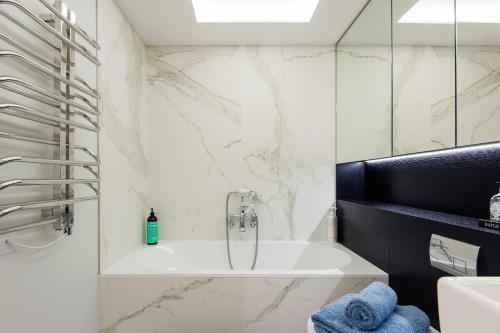 a bathroom with a bath tub and a sink at ARCORE Premium Apartments Oxford Street Area in London