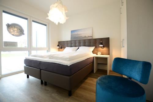 a bedroom with a bed and a blue chair at Luxstay Werder in Kolonie Roeske