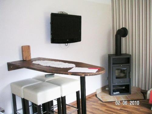 a room with a table and a tv and a stove at FH Charlottchen_WEIG in Ostseebad Karlshagen