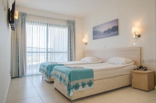 מיטה או מיטות בחדר ב- מלון ר'גינה גורן