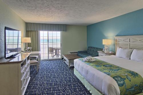 um quarto de hotel com uma cama grande e uma varanda em Sugar Beach Resort Hotel em Traverse City