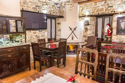 a dining room with a table and chairs and a stone wall at Iliopetra Suites in Agios Lavredios