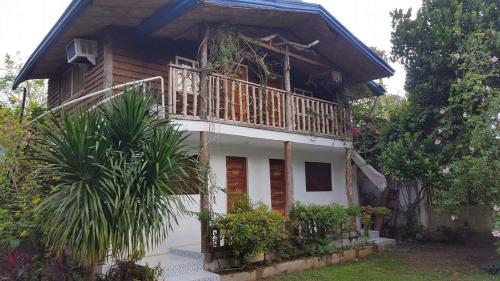 a house with a balcony on top of it at La Vida Hostel Samal Island in Samal