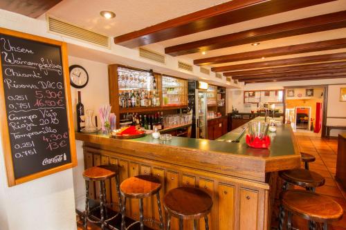 a bar in a restaurant with stools and a chalkboard at Tuniberg Restaurant Hotel in Freiburg im Breisgau