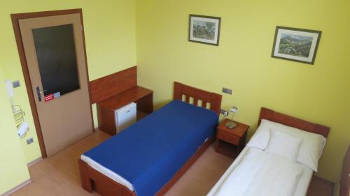 a bedroom with a bed with a blue blanket at Penzion U Splavu in Břeclav