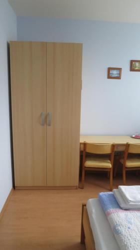 a bedroom with a cabinet and a table and a bed at Penzion U Splavu in Břeclav