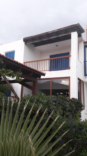 a white house with blue windows and a plant at Rita SeaView Apartment in Pervolia