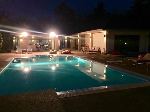 a swimming pool in a yard at night at Sleep Soundly By The Sea in Trat