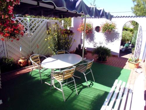 d'une terrasse avec une table, des chaises et une clôture. dans l'établissement Pension Renate Braun, à Gamstädt